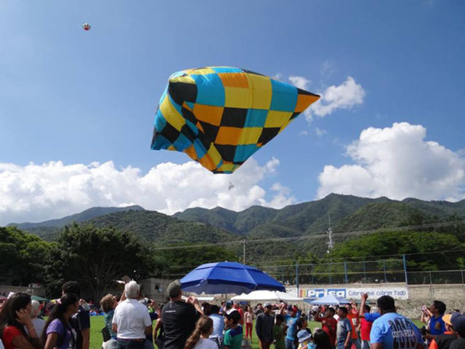 Crowds watch a colorful globo rise during the annual Regata de Globos festival in Ajijic, Lake Chapala, Mexico.